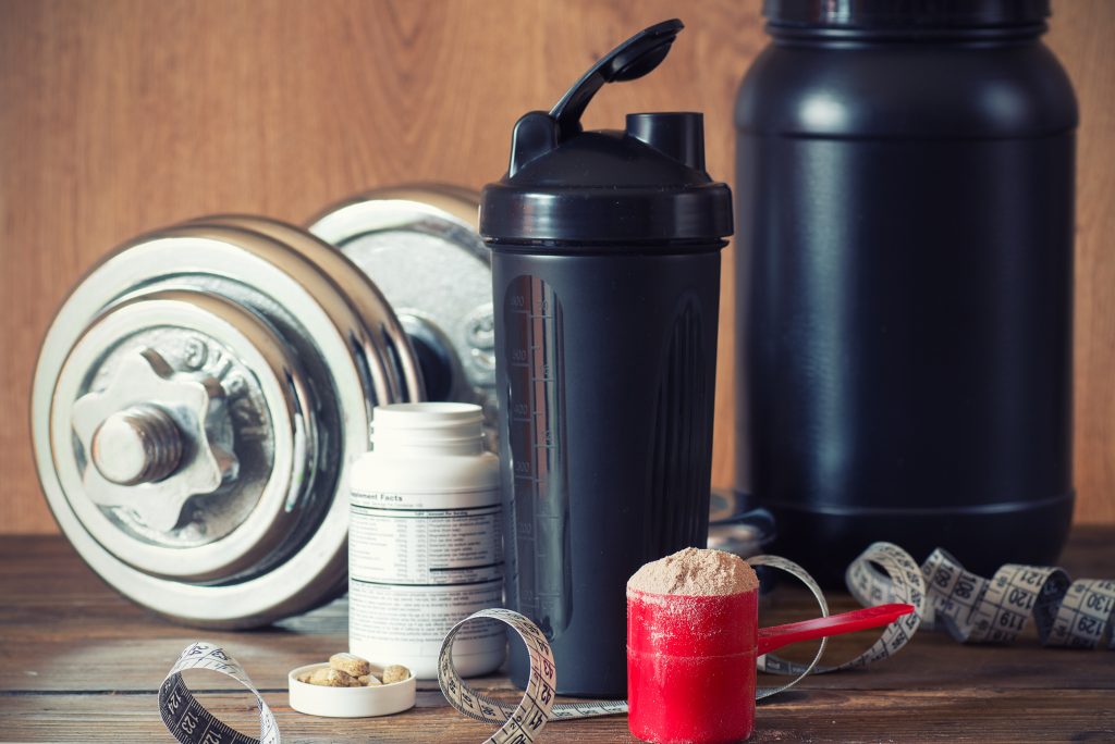 Supplemente Kurzhantel, Pillendose, Proteinpulver und Shaker